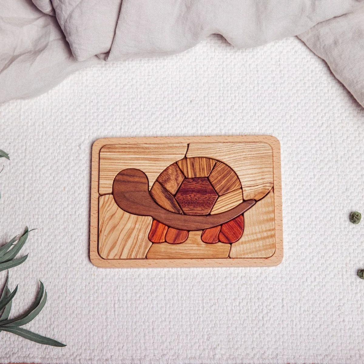 Shelly Slow turtle puzzle fully assembled, flat-lay on waffle playmat, showing walnut, tigerwood, zebrano and mahogany tones