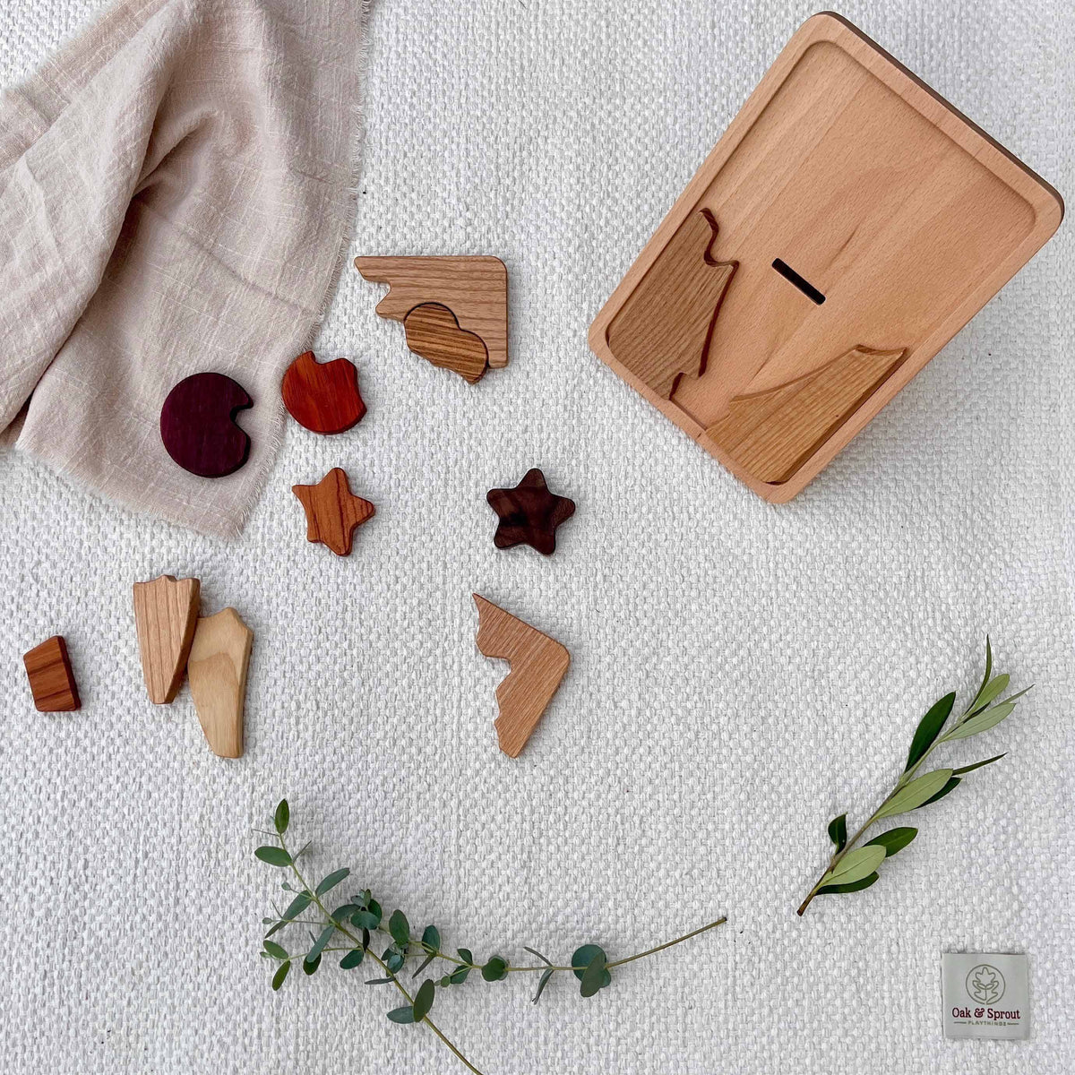 Sky Bloom puzzle fully disassembled, showing Purpleheart, Padauk, Walnut, Tigerwood and Zebrano pieces beside beech board
