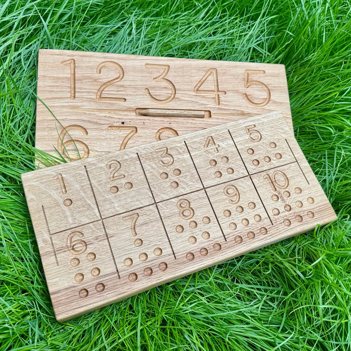 Oak Range number tracing and counting boards on grass, pale maple-toned wood with engraved numerals 1–10 and dot grids