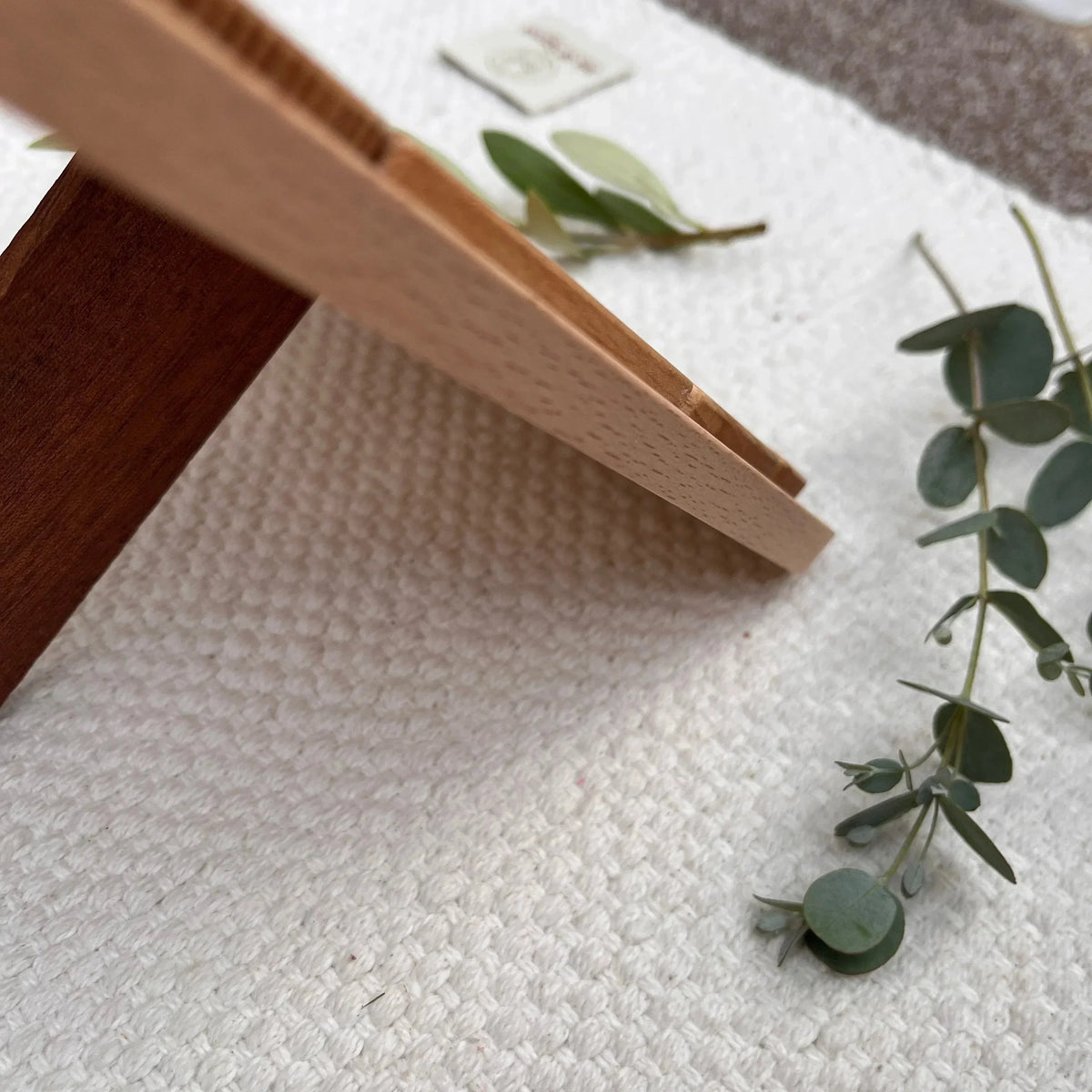 Sweet Scoops wooden ice cream puzzle cone detail in walnut and light-toned wood on cream woven textile with eucalyptus