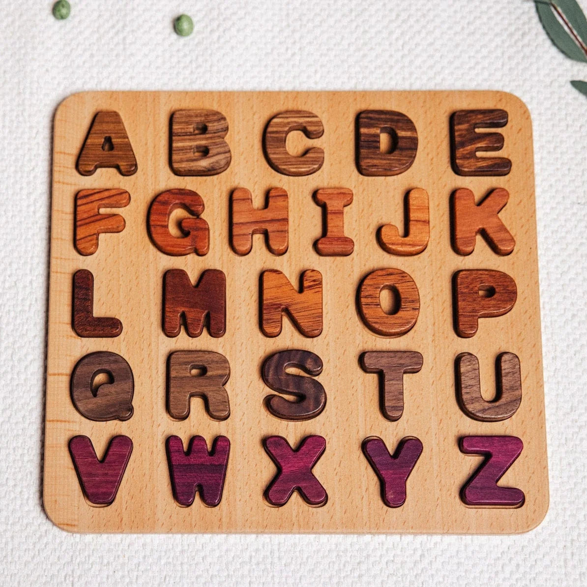 Oak & Sprout Alphabet Puzzle fully assembled, 26 uppercase letters in tigerwood, walnut, purpleheart and zebrano inset board