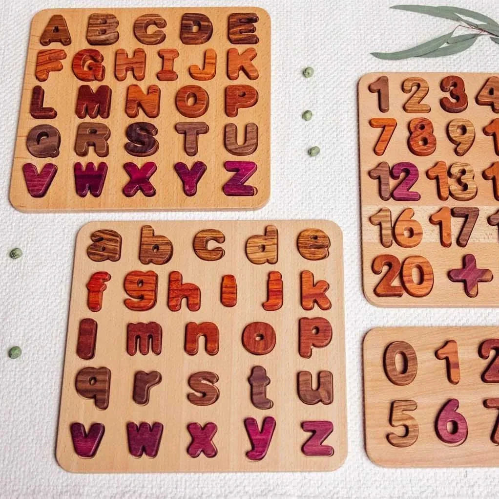 Oak & Sprout lowercase alphabet puzzle fully assembled, showing Purpleheart, Walnut, Tigerwood and Mahogany letter pieces in 