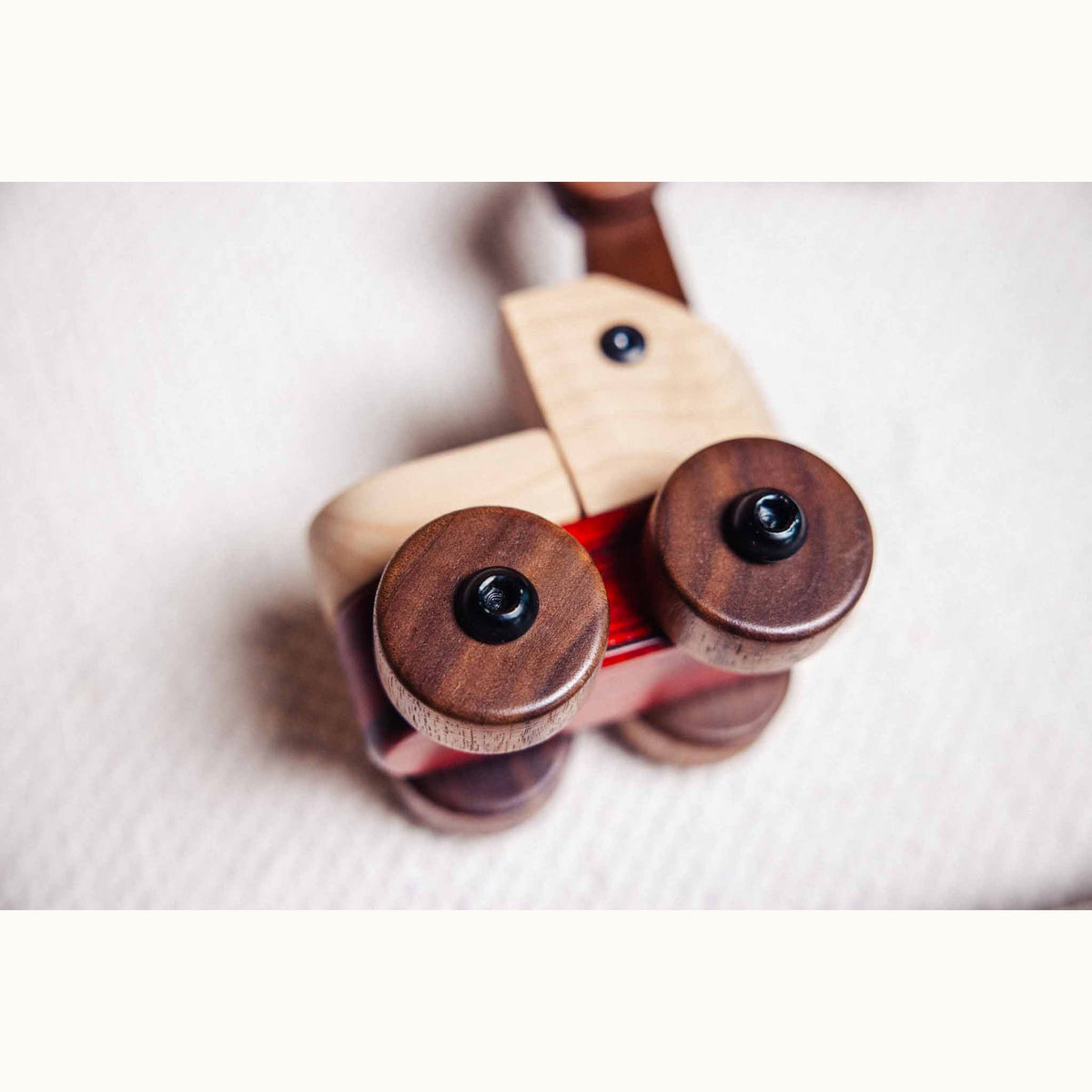 Padauk & Maple Trench Digger front axle close-up: walnut wheels with bolt fixings, maple body, padauk chassis strip