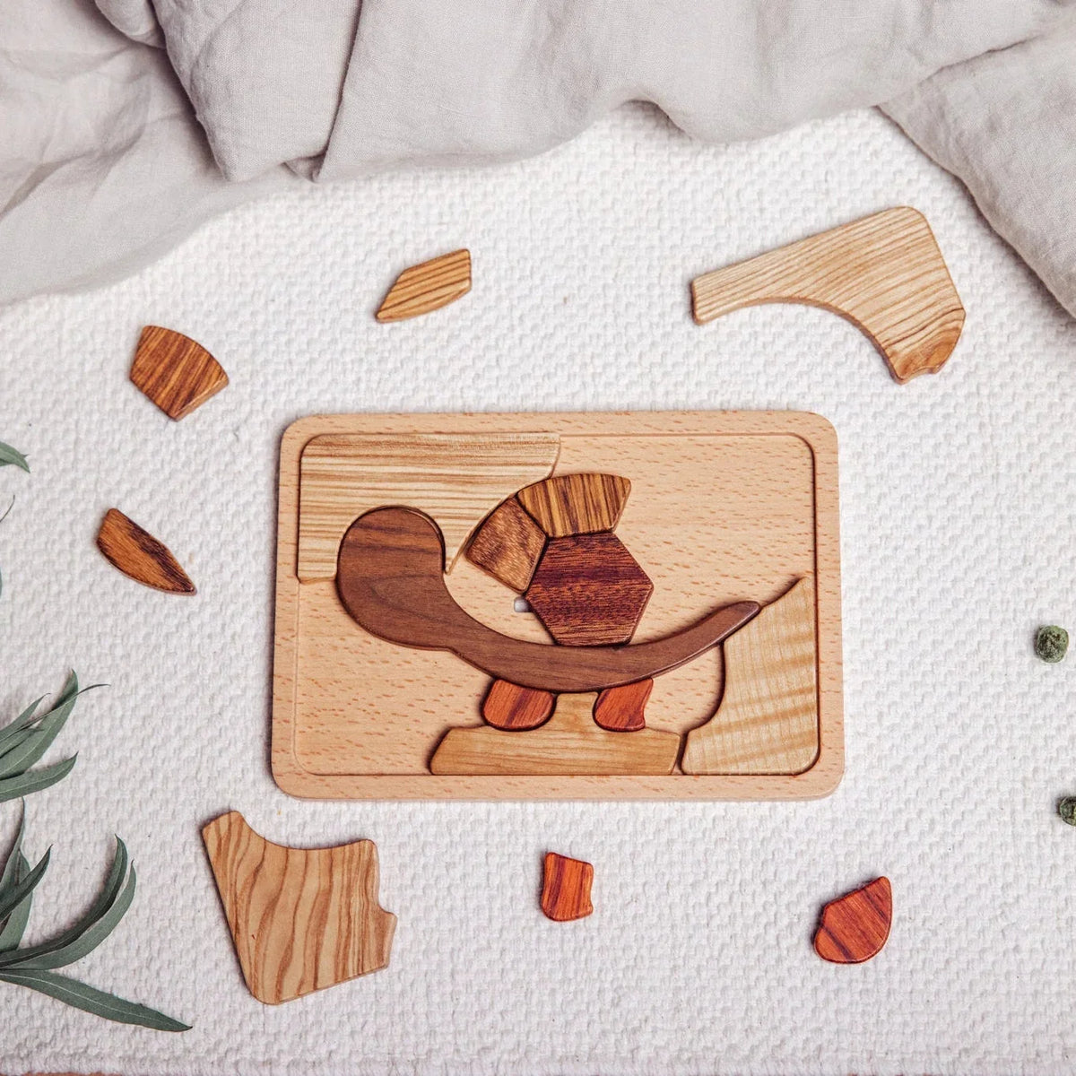 Shelly Slow turtle puzzle partially assembled on white playmat, showing walnut, tigerwood, zebrano and mahogany pieces mid-pl