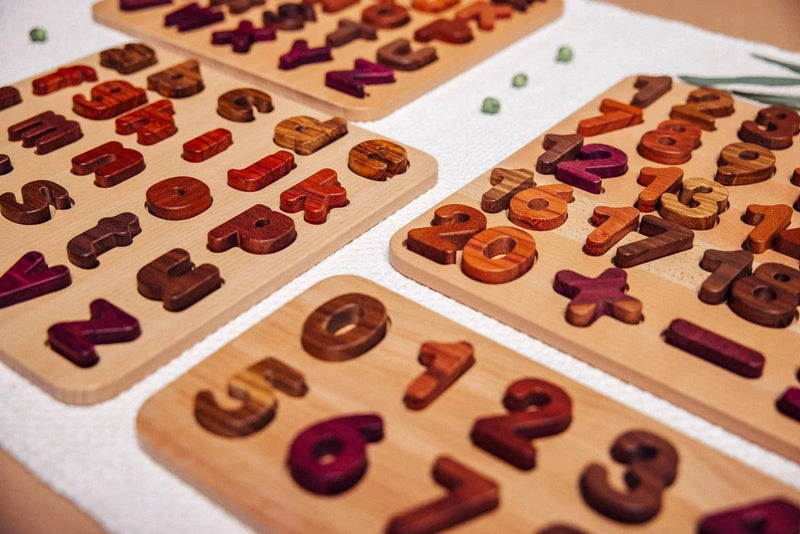 Literacy & Numeracy Bundle: four alphabet and numeral puzzle boards flat-lay, pieces in Purpleheart, Walnut, Tigerwood,